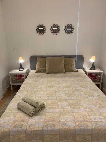 a bedroom with a large bed with two lamps at Cozy canide beach apartment in Canidelo