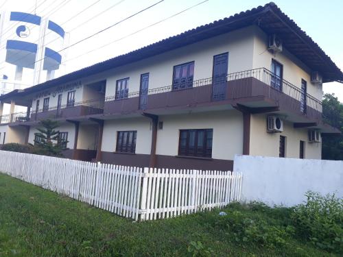 a white house with a fence in front of it at Hotel Araruna in Soure