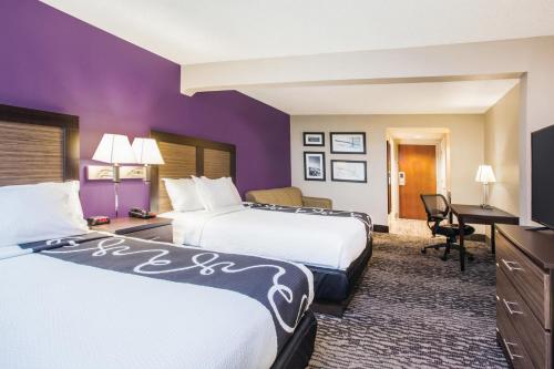a hotel room with two beds and a desk at La Quinta by Wyndham Clearwater South in Clearwater