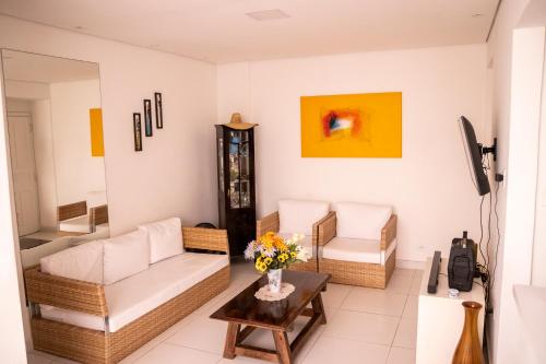 ein Wohnzimmer mit einem Sofa und einem Tisch in der Unterkunft Apartamento com varanda Gourmet na praia da enseada in Guarujá