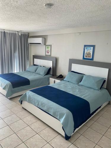 2 camas en un dormitorio con sábanas azules en Isla Verde Studio, en San Juan