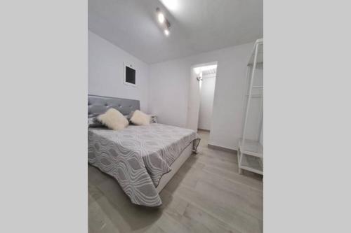 a white bedroom with a bed and a ladder at ROMANTIC BEACH in Puerto del Rosario