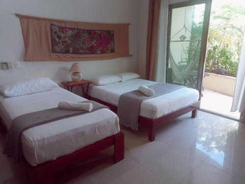 pokój hotelowy z dwoma łóżkami i oknem w obiekcie Villas Akalan w mieście Tulum