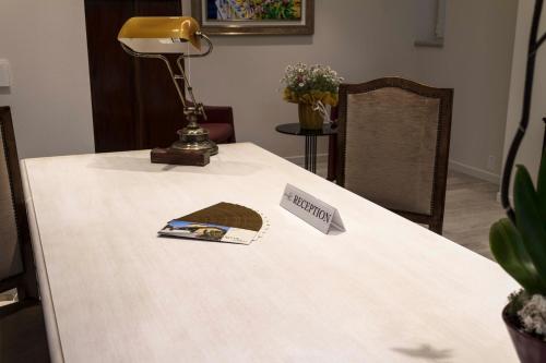 a table with a lamp and a book on it at Hotel Relais Agli Olivi in Lazise