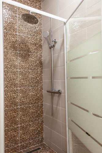 a shower with a glass door in a bathroom at Sunny Studio Apartment in Iaşi
