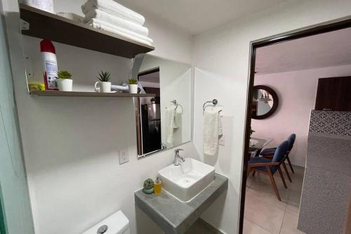 Baño blanco con lavabo y espejo en Departamento *MUNDO VIAJERO* Guadalajara, en Guadalajara