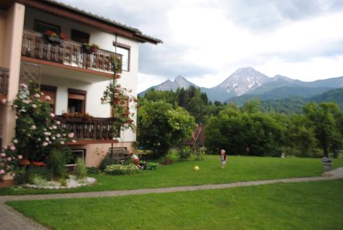una persona in piedi in un cortile accanto a un edificio di Ferienhaus Michor a Latschach ober dem Faakersee