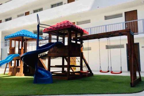 a playground with three slides and a play structure at Departamento *MUNDO VIAJERO* Guadalajara in Guadalajara