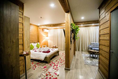 Hyde Park Resort Bishkek2023 في بيشكيك: غرفة نوم مع سرير مع ورود على الأرض