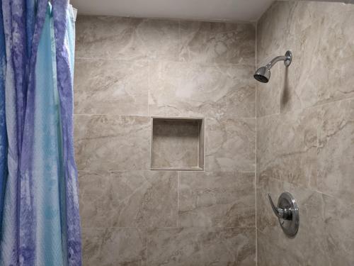 a bathroom with a shower with a blue shower curtain at The Blue Door Inn in Fort Lauderdale