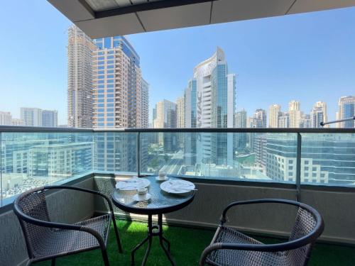 a table and chairs on a balcony with a view of a city at Private gorgeous Room with Marina view with Shared Kitchen in Dubai