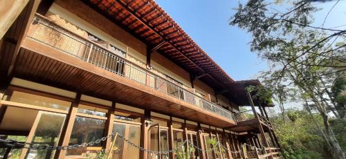 a house with a balcony on the side of it at Canto das Águas Atibaia in Atibaia