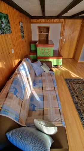 a bed with pillows in a room with wooden floors at Chez Rosalie in La Roche