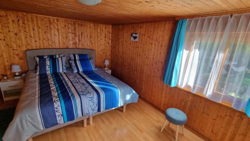 a bedroom with a bed in a wooden room at Chez Rosalie in La Roche