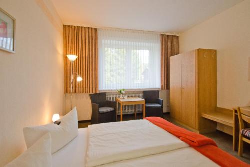 ein Hotelzimmer mit einem Bett und einem Tisch in der Unterkunft Hotel Harz in Hahnenklee-Bockswiese