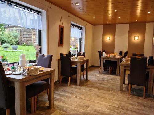 uma sala de jantar com mesas e cadeiras de madeira em Gästehaus Portugall em Ellenz-Poltersdorf