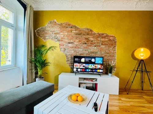 a living room with a couch and a brick wall at Edle Ferienwohnung - Industrial Style in Dresden