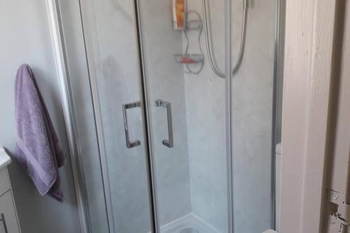 a shower with a glass door in a bathroom at Lovely 1-Bed Apartment at Whitepark Bay Co Antrim in Bushmills