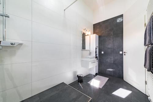 ein Badezimmer mit weißen Wänden und einer Glasdusche in der Unterkunft Apartment 4 an der Messe Friedrichshafen in Friedrichshafen