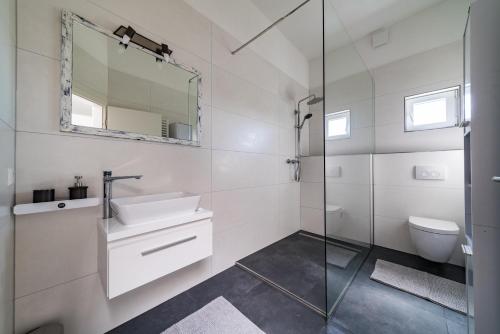 a white bathroom with a sink and a mirror at ApartmentFinke 3 an der Messe Friedrichshafen in Friedrichshafen