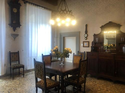 a dining room with a table and chairs and a chandelier at Palazzo Cordoni in Città di Castello