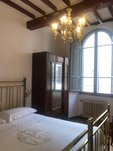 a bedroom with a bed and a chandelier at Palazzo Cordoni in Città di Castello