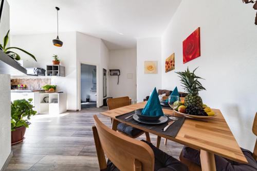 un comedor con una mesa de madera con fruta. en ApartmentFinke 3 an der Messe Friedrichshafen, en Friedrichshafen