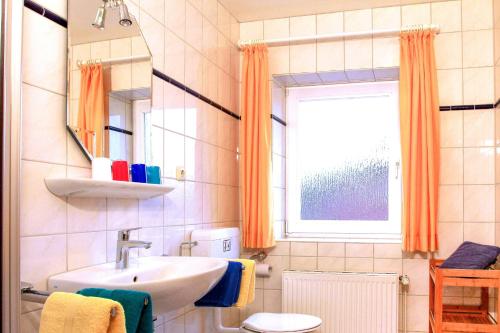 W łazience znajduje się umywalka, toaleta i lustro. w obiekcie Sonnenschein - a52658 w mieście Klausdorf
