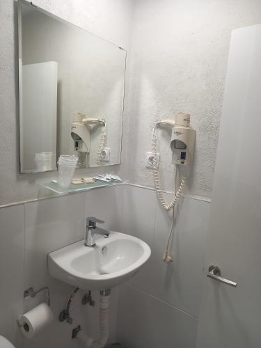 a white bathroom with a sink and a mirror at Casa Inocencio in El Puerto de Santa María