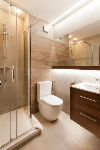 a bathroom with a toilet and a shower and a sink at Tó Wellness Hotel in Bánk