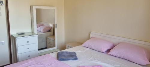 a bedroom with a bed with pink pillows and a mirror at DREAM ISLAND Hotel in Luxor