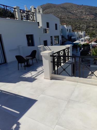 a balcony with chairs and tables on a building at Minois Boutique Hotel in Stalida