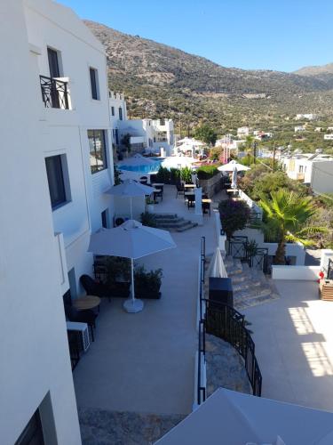 a view of a hotel patio with tables and umbrellas at Minois Boutique Hotel in Stalida