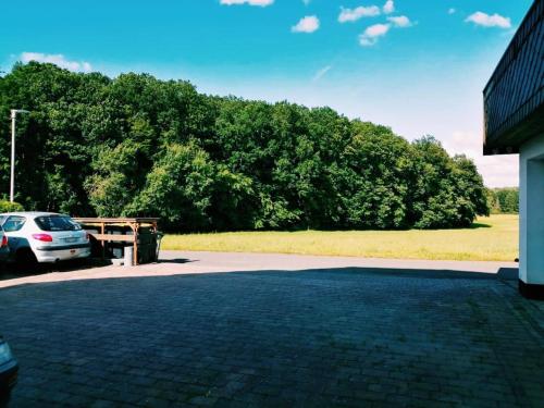 ein Auto parkt auf einem Parkplatz neben einem Feld in der Unterkunft 76 qm Whg im EG Haus-Wohlfühloase vor der Haustür in Gladenbach