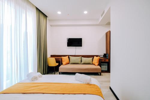 a bedroom with a large bed and a couch at Hotel Doesi in Tbilisi City