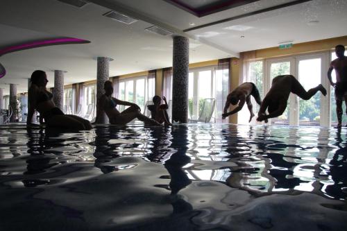 a group of people sitting in the water in a swimming pool at Tó Wellness Hotel in Bánk