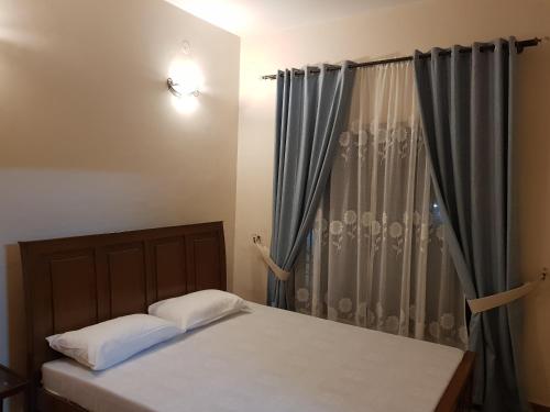 a bed with two pillows in front of a window at Entire Apartment 2bed Condo at Burban Oakwood in Bhurban