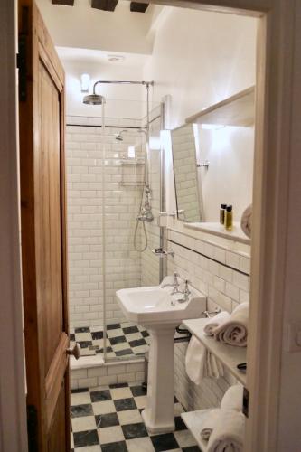 une salle de bain blanche avec un lavabo et un miroir dans l'établissement FULLY RENOVATED very quiet charming 2bed/2bath flat in the Marais sleeps up to 4, à Paris
