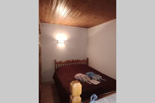 - une petite chambre avec un lit et un plafond en bois dans l'établissement Rent flat Cevedale, à Santa Caterina di Valfurva
