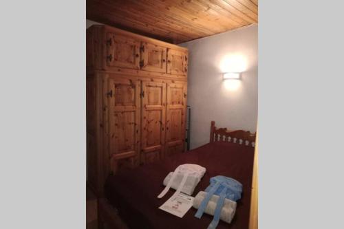 a bedroom with a bed with a wooden cabinet at Rent flat Cevedale in Santa Caterina Valfurva