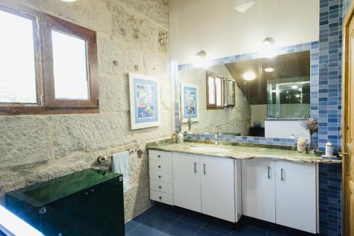 y baño con lavabo y espejo. en Villa Casa de Campo Los Carballos en Tomiño