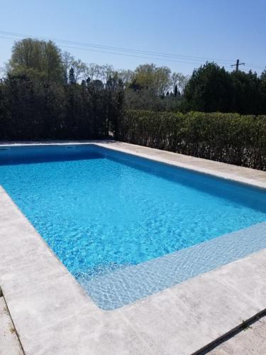 une grande piscine bleue dans une cour dans l'établissement Appartement 2 pers avec accès piscine, à Saint-Rémy-de-Provence