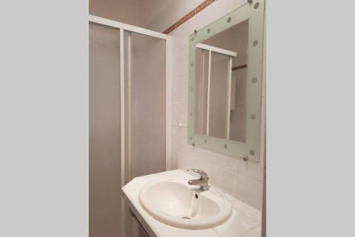 bagno bianco con lavandino e specchio di Appartement 2 pers avec accès piscine a Saint-Rémy-de-Provence