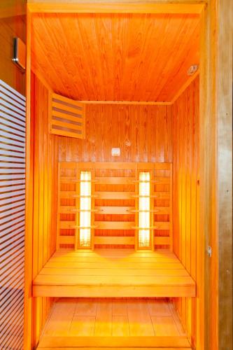 a sauna with two windows in a wooden room at Tó Wellness Hotel in Bánk