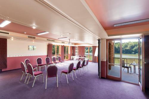 a conference room with a long table and chairs at Tó Wellness Hotel in Bánk