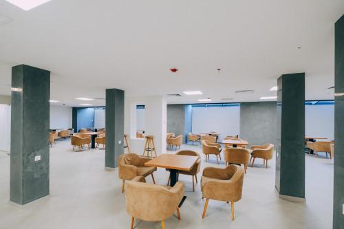 a waiting area with tables and chairs in a building at Hotel Doesi in Tbilisi City