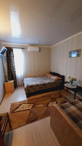 a small bedroom with a bed and a table at Otdykh u moria in Fontanka