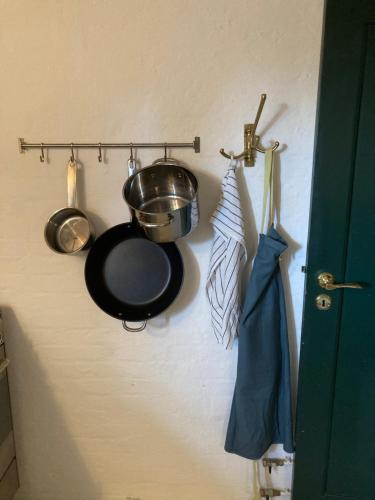 a kitchen with a pot and pans on a wall at Villa Wiegand - a room with a view in Holbæk