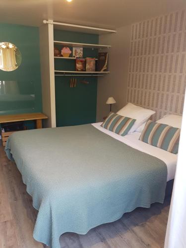 um quarto com 2 camas e uma parede verde em LES LUPINS em Étretat
