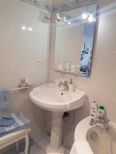 bagno con lavandino, specchio e servizi igienici di LES LUPINS a Étretat